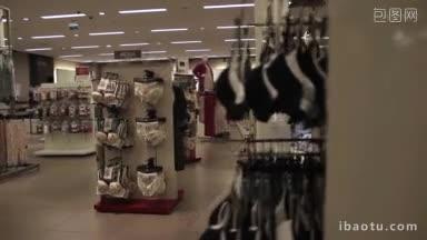 服装的内部服装商店不同的服装挂在衣架上，在精品时装店的货架上排成一排